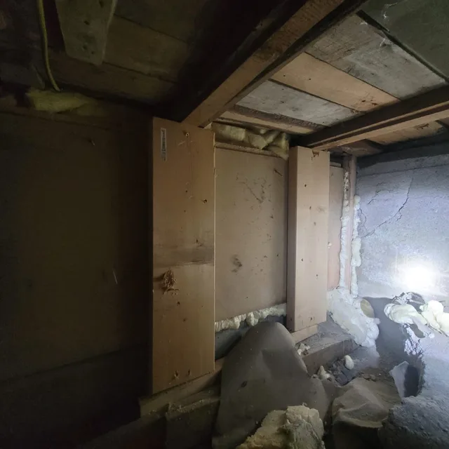 Sprekker i mur ved siden av åpent bindingsverk